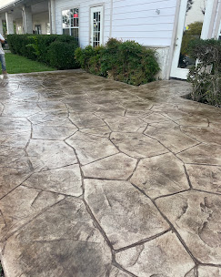 Stamped flagstone-pattern concrete walkway leading to a white home